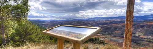 Mesa de interpretación con paisaje nublado al fondo