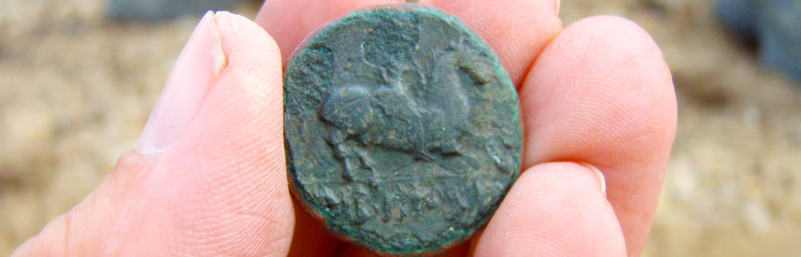Moneda romana hallada por un arqueólogo durante una prospección